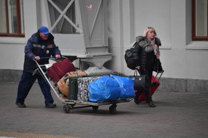 Москва.  Носильщик перевозит багаж.