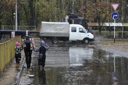 Ставрополь. Женщина с детьми идет под дождем.