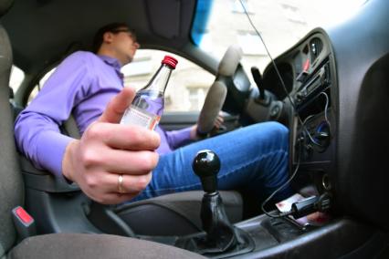 Новосибирск.  Мужчина за рулем автомобиля держит в руке чекушку водки.
