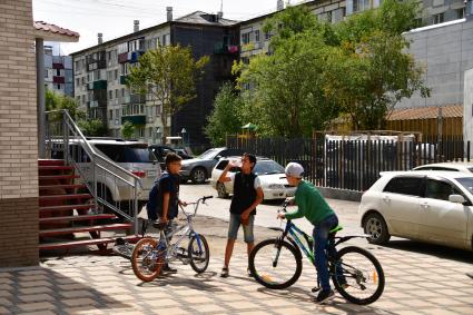 Сахалин, Южно-Сахалинск.  Мальчики  с велосипедами на улице города.