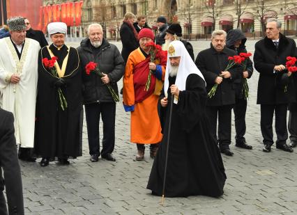 Москва.  Патриарх Московский и всея Руси Кирилл (в центре),  председатель Духовного управления мусульман Карачаево-Черкесской Республики Исмаил Бердиев, председатель совета муфтиев России Равиль Гайнутдин (слева направо на втором плане),  глава Буддийской традиционной сангхи России Пандито Хамбо лама Дамба Аюшеев (в центрена втором плане), председатель Высшего совета Общероссийского общественного движения `Российский конгресс народов Кавказа` Асламбек Паскачев (справа) и Заместитель председателя комитета Госдумы РФ по делам СНГ, евразийской интеграции и связям с соотечественниками Виктор Водолацкий (второй справа) на церемонии возложения цветов к памятнику Минину и Пожарскому на Красной площади в рамках празднования Дня народного единства.