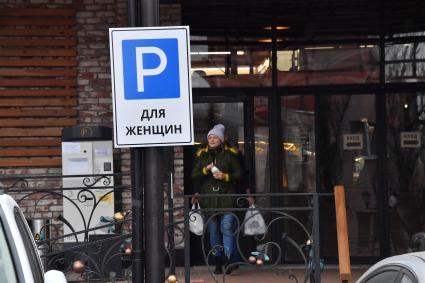 Москва. Дорожный знак `Парковка для женщин` установлен возле главного входа на Усачевский рынок.