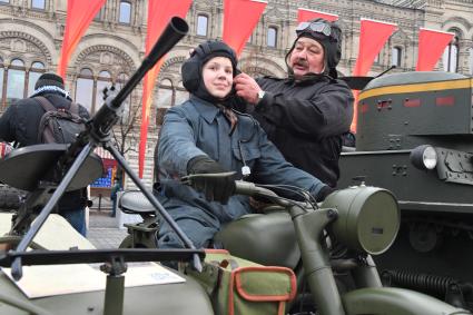 Москва. Мальчик на мотоцикле перед началом торжественного марша, посвященного 76-й годовщине военного парада 1941 года, на Красной площади.