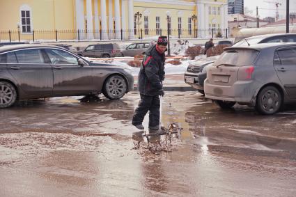 Екатеринбург. Дворник убирает грязь с парковки