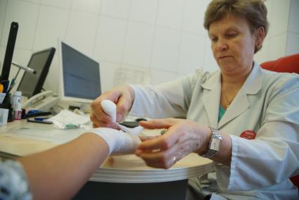 Екатеринбург. Врач-травматолог бинтует руку девушке во время приема в травмпункте