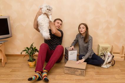 Челябинск. Девушка и молодой человек с котом в новой квартире.