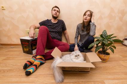 Челябинск. Молодые люди с котом в новой квартире.