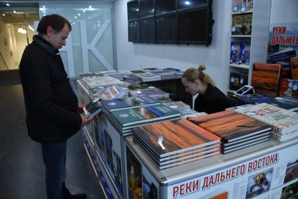 Москва. Покупатель у  книжного  киоска  `Комсомольской правды`на фестивале Русского географического общества в Центральном доме художников на Крымском валу.