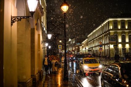 Москва.  Прохожие во время снегопада на Никитском бульваре.