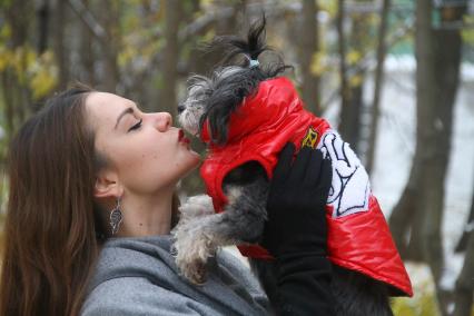 Нижний Новгород. Женщина держит на руках собаку одетую в комбинезон.