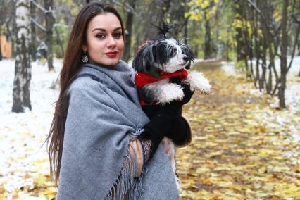 Нижний Новгород. Женщина держит на руках собаку одетую в комбинезон.