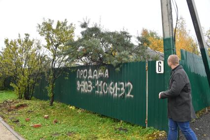Москва. Мужчина читает объявление о продаже у миграционного центра в деревне Сахарово..