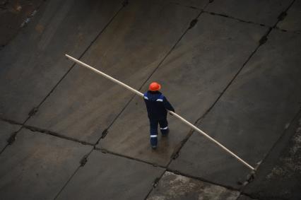 Москва.  Рабочий несет доску.