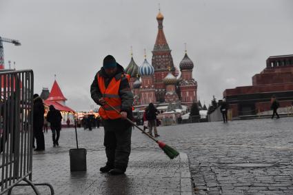 Москва.  Сотрудник коммунальной службы во время уборки  на Красной площади.