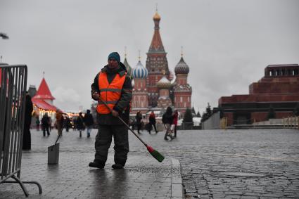 Москва.  Сотрудник коммунальной службы во время уборки  на Красной площади.