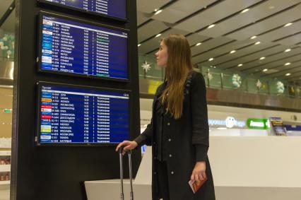 Санкт-Петербург. Девушка  с чемоданом перед вылетом в аэропорту Пулково.