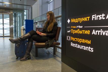 Санкт-Петербург. Девушка  с чемоданом перед вылетом в аэропорту Пулково.