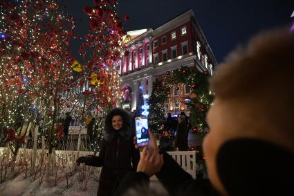 Москва.  Девушка фотографируется  на Тверской улице.