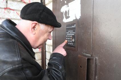 Русиново.  Слабовидящий мужчина набирает код подъезда.