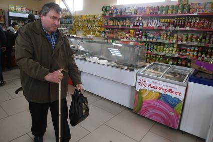 Русиново.   Слабовидящий мужчина покупает продукты в магазине.