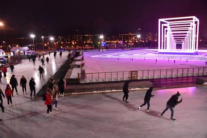 Москва.  Посетители катаются на катке в Парке Горького.