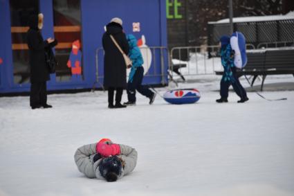 Москва. Девушка лежит на снегу в парке искусств `Музеон`.