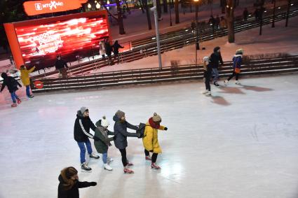 Москва.  Посетители катаются на катке в Парке Горького.