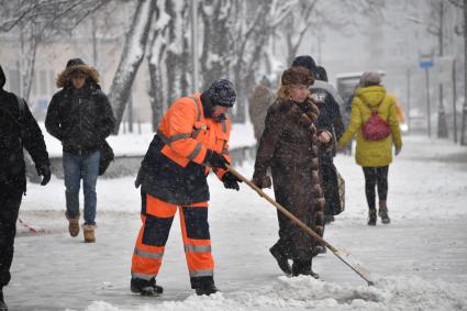 Москва. Сотрудница коммунальной службы во время уборки снега.