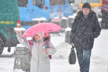 Москва. Девочка с зонтом во время снегопада.