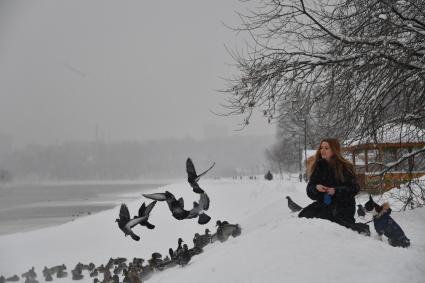 Москва. Девушка кормит голубей и уток на территории музея-заповедника `Коломенское`.