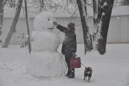 Москва.  Девушка с собакой во время прогулки  по территории музея-заповедника `Коломенское`.