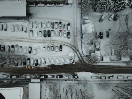 Москва. Заснеженные автомобили на парковке.