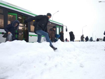 Москва.   Пассажиры выходят из автобуса на остановке у метро `Саларьево`.