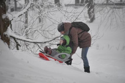 Москва. Женщина везет ребенка на санках.