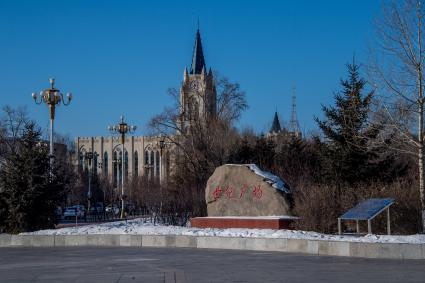 Китай, Хэйхэ. Здание Дворца спорта в форме готического собора (на заднем плане).