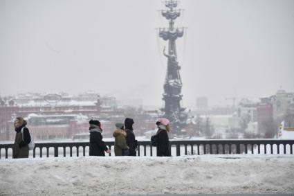 Москва. Молодые люди  на заснеженной Крымской набережной.