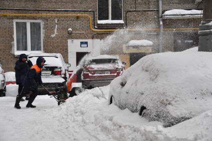 Москва. Сотрудник коммунальных служб убирает снег во дворе.