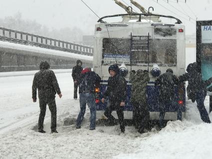 Москва.  Пассажиры толкают троллейбус во время сильного снегопада.