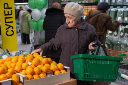 Санкт-Петербург.  Женщина выбирает апельсины в супермаркете `Перекресток`.