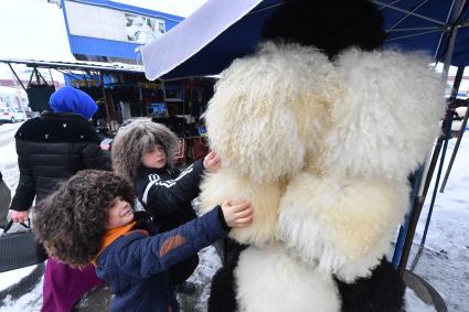 Чечня, Грозный. Мальчики примеряют папахи  на городском  рынке.