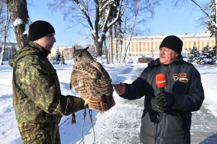 Москва. Корреспондент `Комсомольской правды` Александр Гамов ( справа  )   и  военнослужащий   Соколиной службы комендатуры Московского Кремля  с  филином Филей.