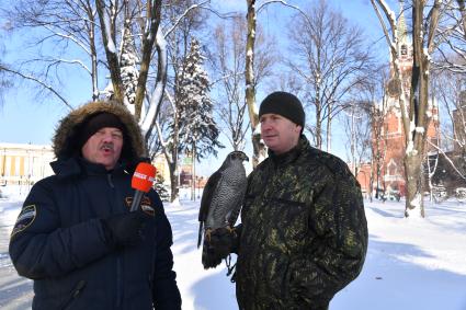 Москва. Корреспондент `Комсомольской правды` Александр Гамов (слева)  и в оеннослужащий   Соколиной службы комендатуры Московского Кремля  с соколом Альфой.