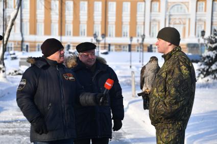 Москва. Корреспондент `Комсомольской правды` Александр Гамов  , советник директора ФСО России Сергей Девятов и  военнослужащий   Соколиной службы комендатуры Московского Кремля  с соколом Альфой ( слева направо).