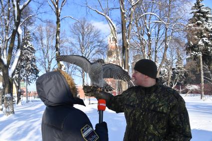 Москва. Корреспондент `Комсомольской правды` Александр Гамов (слева)  и в оеннослужащий   Соколиной службы комендатуры Московского Кремля  с соколом Альфой.