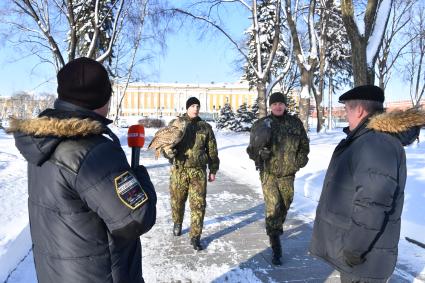 Москва. Корреспондент `Комсомольской правды` Александр Гамов  , советник директора ФСО России Сергей Девятов ( справа)  и  военнослужащие   Соколиной службы комендатуры Московского Кремля  с соколом Альфой   и филином Филей.