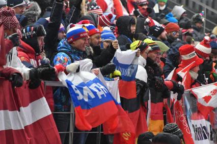 Южная Коре, Пхенчхан. Российские болельщики с российскими флагами на соревнованиях по санному спорту среди мужчин на XXIII зимних Олимпийских играх.