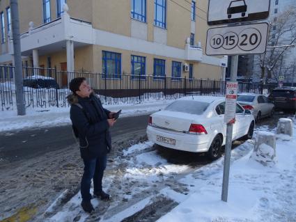 Москва.  Корреспондент `Комсомольской правды` Павел Клоков   у знака платной парковки.