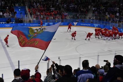 Южная Корея,  Каннын.   Российский флаг на трибуне во время матча группового этапа  между  командой олимпийских спортсменов из России и  сборной  США на соревнованиях по хоккею на  XXIII зимних Олимпийских играх.