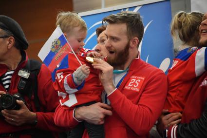 Москва. Хоккеист  Михаил Григоренко  с сыном на руках во время  церемонии  встречи российских спортсменов-участников Олимпиады 2018 в аэропорту `Шереметьево`.