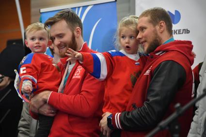 Москва. Хоккеисты  Михаил Григоренко  с сыном  и  Сергей Андронов с дочкой (слева направо)  во время  церемонии  встречи российских спортсменов-участников Олимпиады 2018 в аэропорту `Шереметьево`.